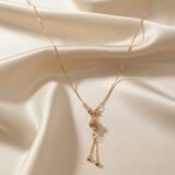 Gold plated drop pendant necklace with textured ball charm and tassel chain for women